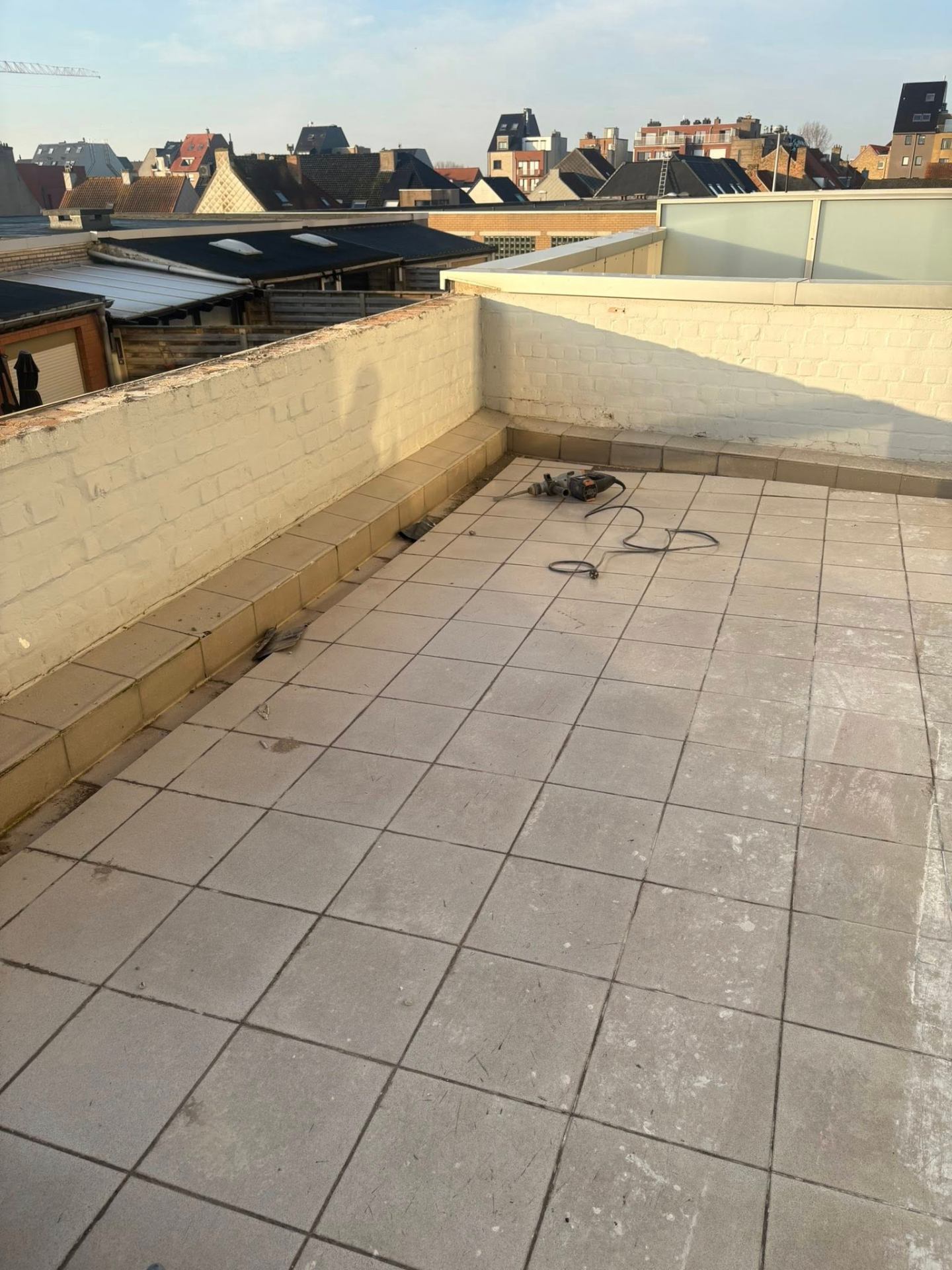 Versleten terrastegels op balkon vóór renovatie